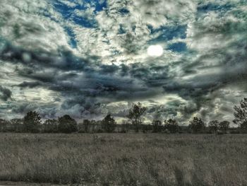 Scenic view of field against cloudy sky