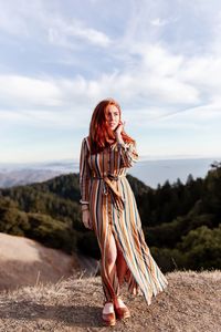 Woman standing on mountain against sky