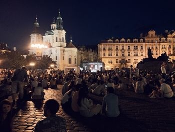Group of people at illuminated historic building at night