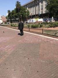 Rear view of man walking on street in city