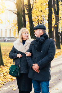 Mature couple walking in park during autumn