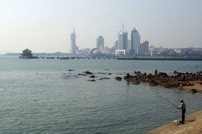 Scenic view of sea and cityscape against sky