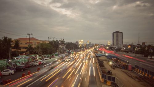 Light trails on road along cityscape