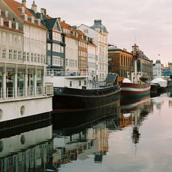 Boats moored in water against sky