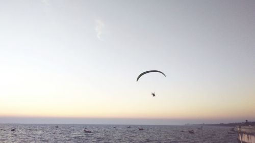Paraglider over sea against sky