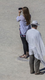 Full length of people standing on sand at beach