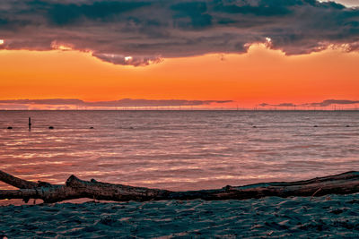 Scenic view of sea against dramatic sky during sunset