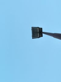 Low angle view of street light against blue sky