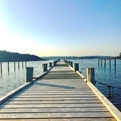 Pier over lake against clear sky