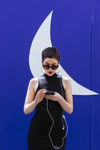 Woman standing against wall in city