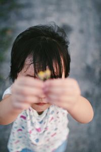 Close-up of girl holding tiny flowers