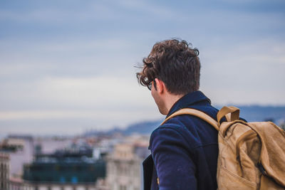 Rear view of a man with cityscape in background