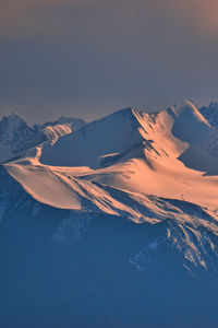 Scenic view of snowcapped mountains against sky during sunset