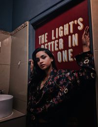 Young woman standing against wall