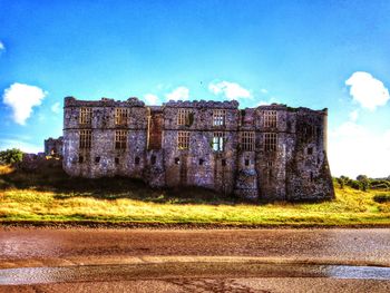 Built structure on landscape against blue sky