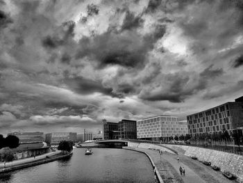 Bridge over river against cloudy sky