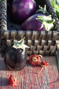 Still life with basket, eggplants, garlic chives, dried red peppers