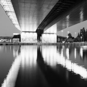 Bridge over river in city against sky