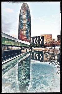 Reflection of buildings in river against sky