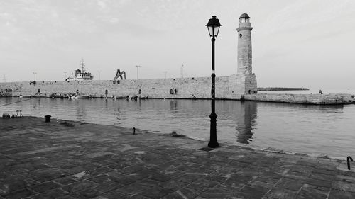 View of lighthouse by sea against sky
