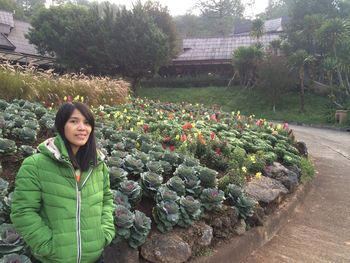 Portrait of smiling woman standing against plants