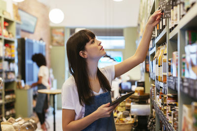 Young woman looking away while standing in store