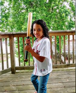 Portrait of smiling woman standing against railing