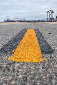 Surface level of yellow road against sky