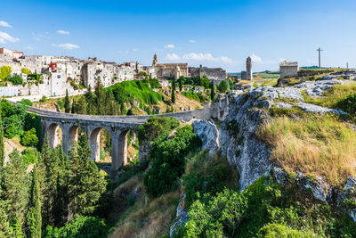 Arch bridge over river against sky