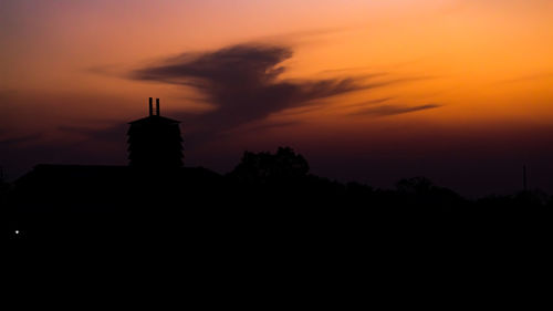 Silhouette building against sky during sunset