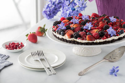 A delicious homemade mixed berry cheesecake tart with a chocolate cookie base.