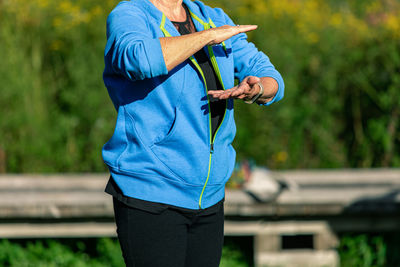 Midsection of man holding blue while standing outdoors