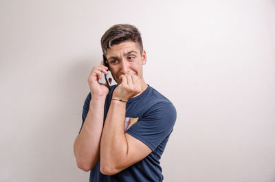 Young man using smart phone against white background