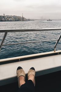 Low section of woman in boat sailing on sea