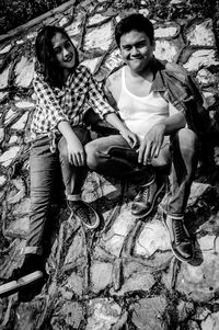 Portrait of smiling young couple sitting outdoors