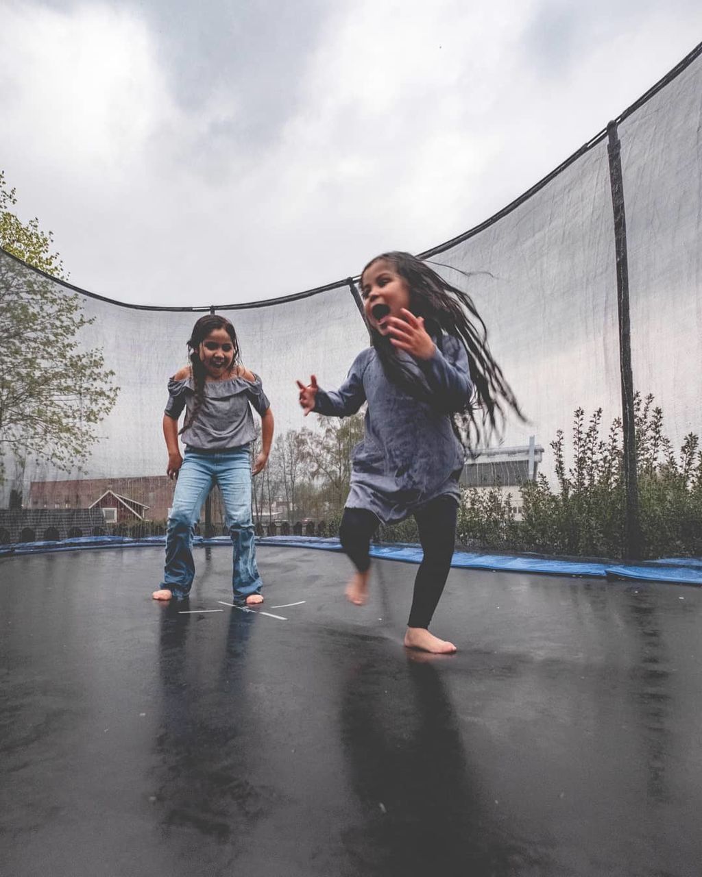 full length, two people, child, happiness, childhood, emotion, girls, fun, women, real people, motion, enjoyment, females, casual clothing, togetherness, sky, leisure activity, smiling, front view, positive emotion, outdoors, rain, sister