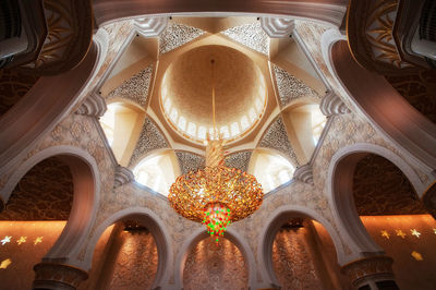 Low angle view of chandelier hanging from ceiling in mosque