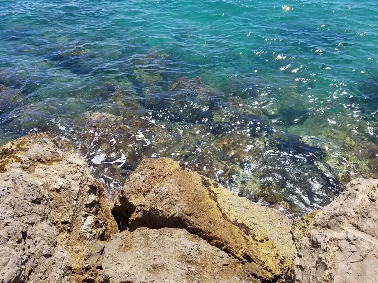 HIGH ANGLE VIEW OF ROCKS ON SEA