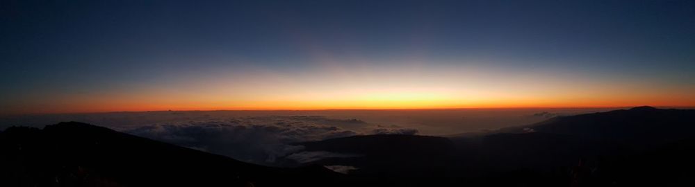 Scenic view of silhouette mountains against sky at sunset