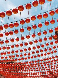 Low angle view of red lanterns hanging against sky