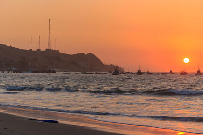 Scenic view of sea against orange sky