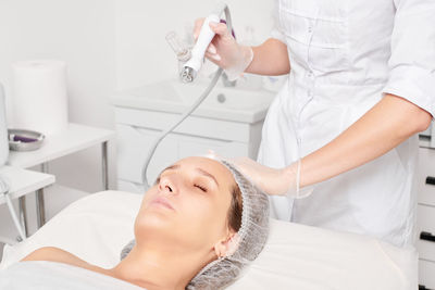 Midsection of female dentist examining patient in clinic