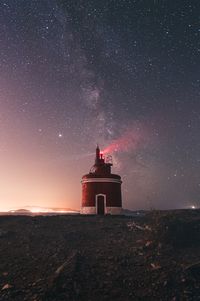 Lighthouse against sky at night