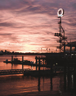 Silhouette pier over sea against sky during sunset