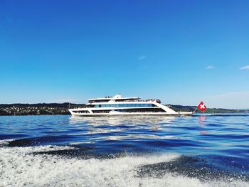 Ship in sea against clear blue sky