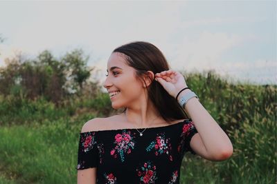 Beautiful young woman standing on field