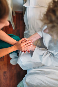 Nurse consoling senior patient in hospital