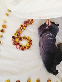 High angle view of hand holding white rose on table