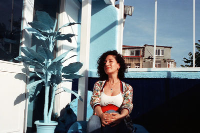 Portrait of woman sitting outside building