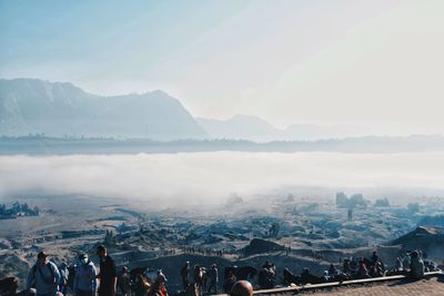 People on mountains against sky during winter